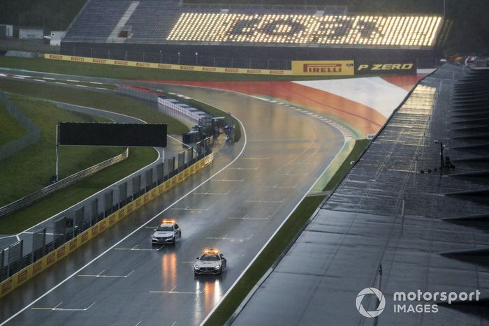Safety Car and Medical Car driving round in heavy rain