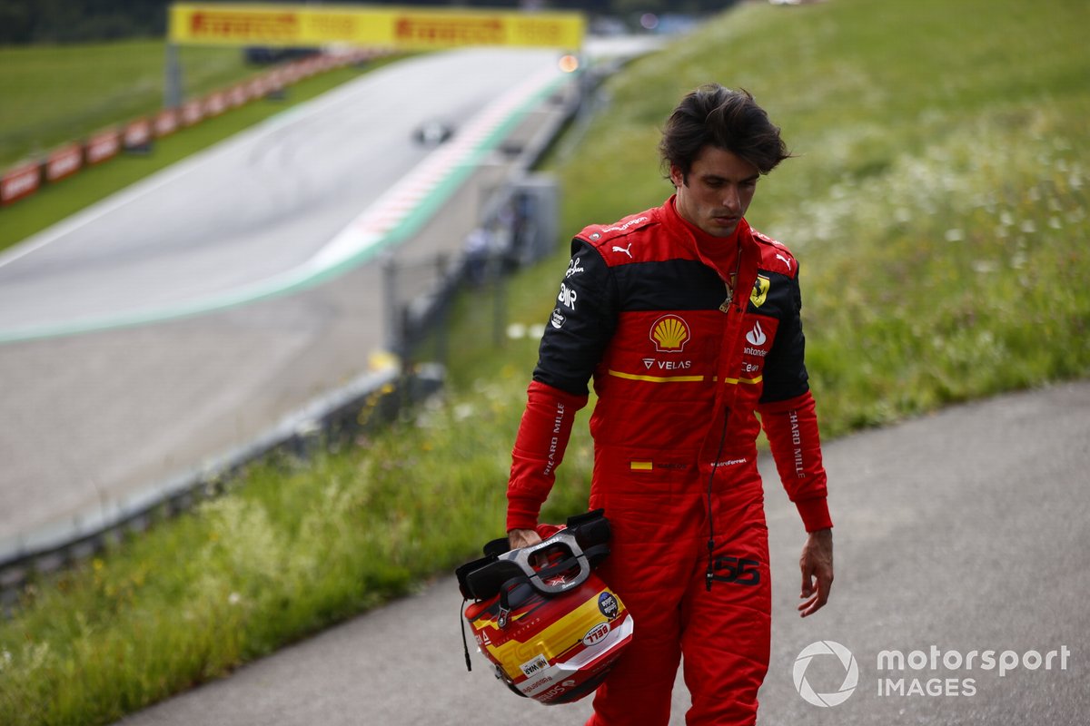 Carlos Sainz, Ferrari, walks away from his car after a fire