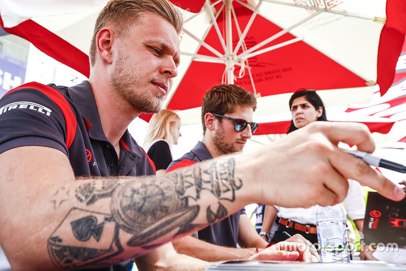 Kevin Magnussen, Haas F1 Team, and Romain Grosjean, Haas F1 Team, sign autographs for fans