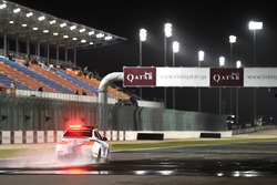 La voiture de sécurité en piste pour inspecter la piste humide