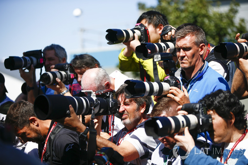 A bank of photographers take aim at their subject