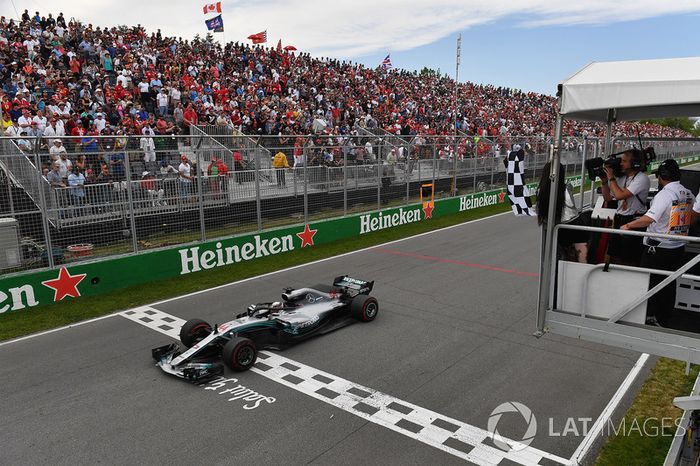 Lewis Hamilton, Mercedes-AMG F1 W09 llega a la bandera a cuadros ondeada por Winnnie Harlow 