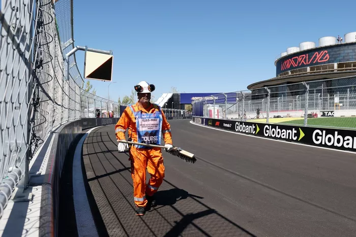 Marshal sweeps debris from the track