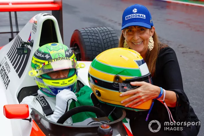 Lewis Hamilton en la cabina del McLaren MP4/5B, con Viviane Senna, hermana de Ayrton Senna, sosteniendo el casco de su hermano.