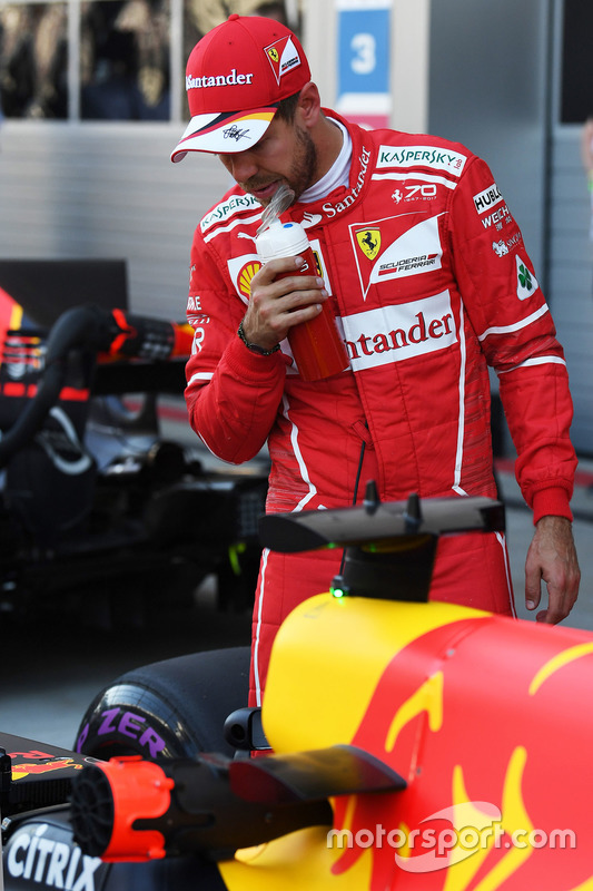 Pole sitter Sebastian Vettel, Ferrari looks at the Red Bull Racing RB13 in parc ferme