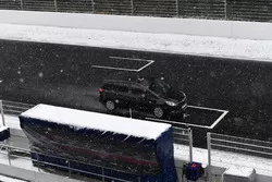 Officials controleren de baan tijdens een sneeuwbui
