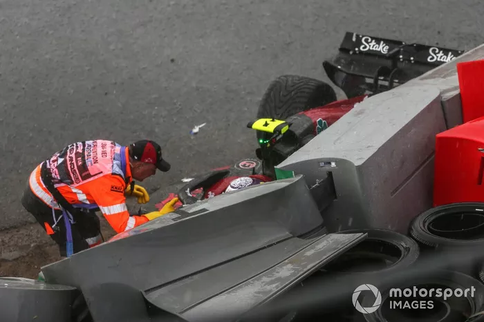 Un comisario controla a Zhou Guanyu, Alfa Romeo C43, tras un accidente