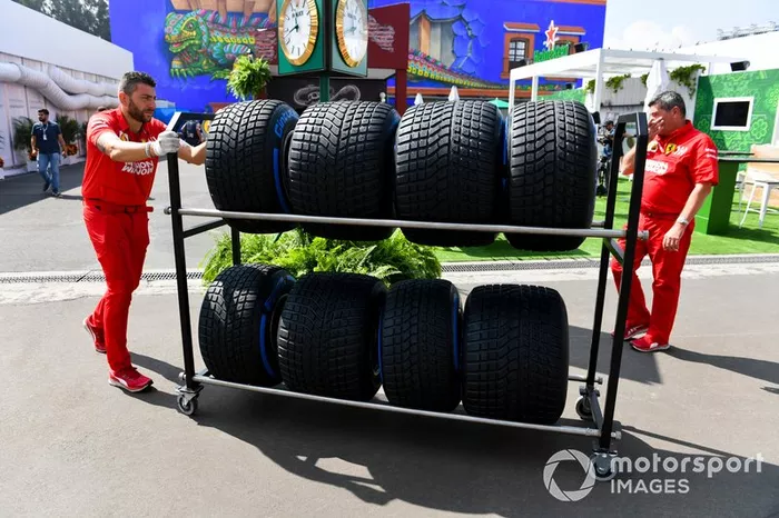 Mecánico de Ferrari con neumáticos Pirelli para lluvia en el paddock 