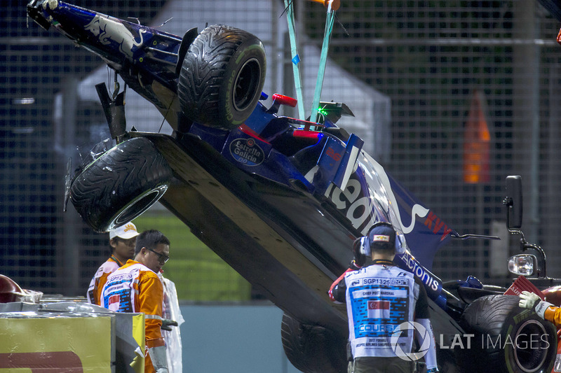 Marshals supervise a crane removing the wrecked Daniil Kvyat Scuderia Toro Rosso STR12