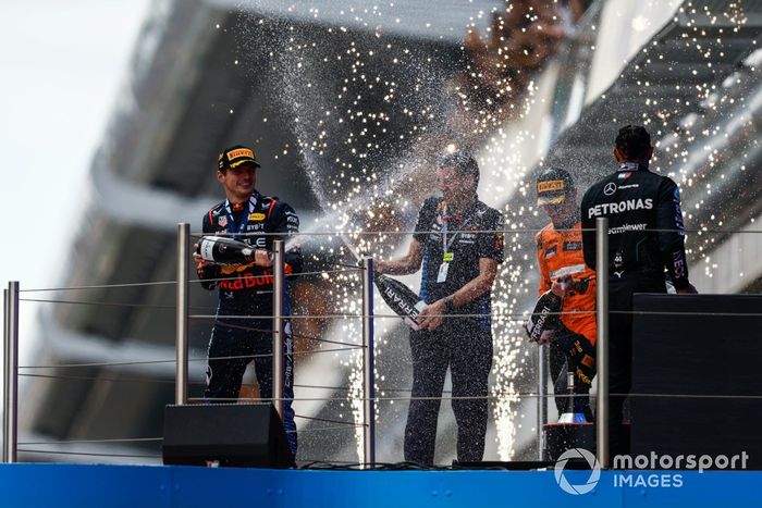 Max Verstappen, Red Bull Racing, 1ª posición, rocía con champán al delegado de trofeos de Red Bull Racing en el podio. 