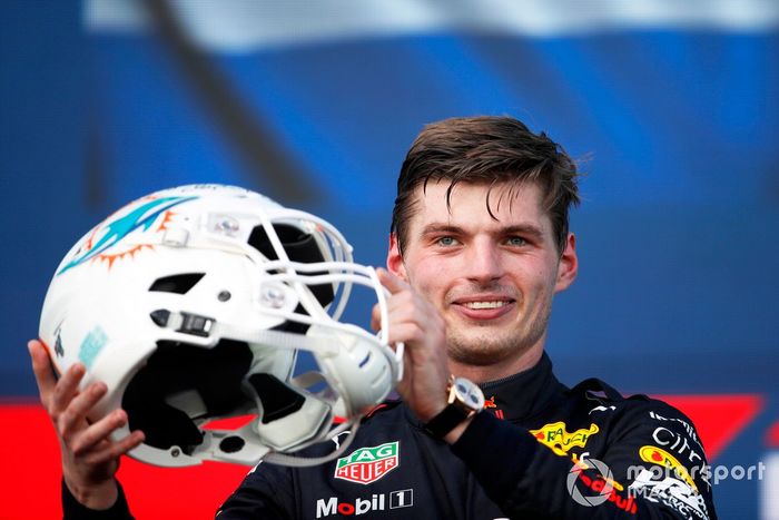 Max Verstappen, Red Bull Racing, 1ª posición, recibe un casco de NFL de los Miami Dolphins en el podio