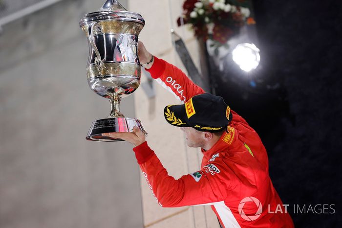 Sebastian Vettel, Ferrari, 1st position, holds up his trophy on the podium