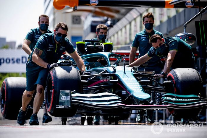Los mecánicos mueven el coche de Lance Stroll, Aston Martin AMR21