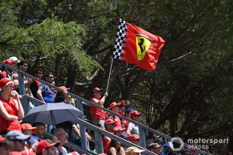 Des fans agitent un drapeau Ferrari dans une tribune