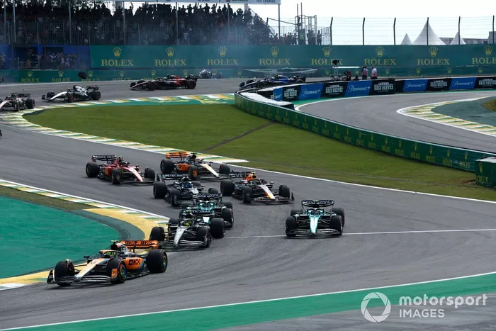 Lando Norris, McLaren MCL60, Lewis Hamilton, Mercedes F1 W14, Fernando Alonso, Aston Martin AMR23, el resto de la parrilla en la salida mientras Alex Albon, Williams FW45, Kevin Magnussen, Haas VF-23, chocan al fondo.