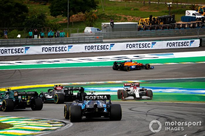 Lewis Hamilton, Mercedes W12, Lance Stroll, Aston Martin AMR21, mientras Kimi Raikkonen, Alfa Romeo Racing C41, hace un trompo en la primera vuelta