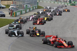 Sebastian Vettel, Ferrari SF71H, voor Max Verstappen, Red Bull Racing RB14, Valtteri Bottas, Mercedes AMG F1 W09, Lewis Hamilton, Mercedes AMG F1 W09, Kimi Raikkonen, Ferrari SF71H, Daniel Ricciardo, Red Bull Racing RB14, en the rest of the field at the start of the race
