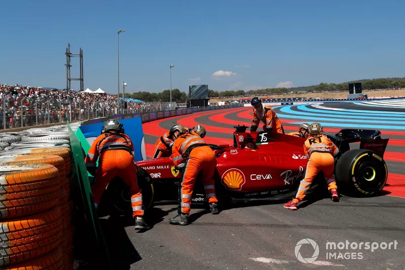 Oficiales de pista retiran el coche dañado de Charles Leclerc, Ferrari F1-75, tras su accidente 