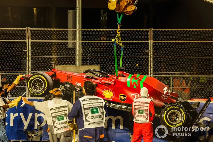 Los oficiales de pista retiran el coche de Charles Leclerc, Ferrari SF21, del circuito