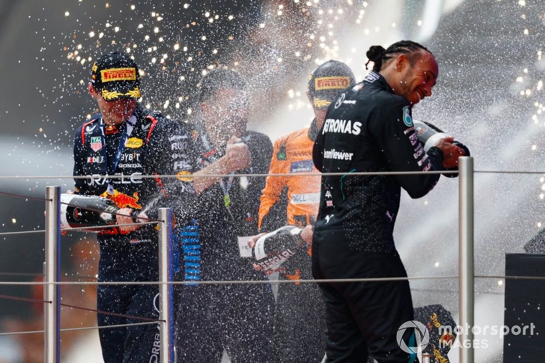 Max Verstappen, Red Bull Racing, 1. miejsce, rozpyla szampana podczas świętowania Lewis Hamilton, Mercedes-AMG F1 Team, 3. miejsce, na podium 