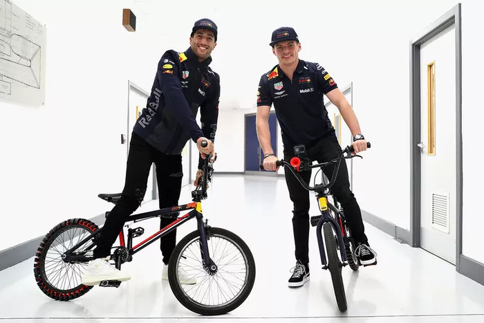 Max Verstappen, Red Bull Racing, y Daniel Ricciardo, Red Bull Racing, montan bicicletas en la fábrica
