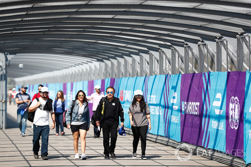 Spectators walk along the over track bridge