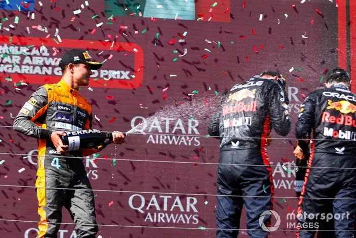 Lando Norris, McLaren, 2ª posición, rocía a Max Verstappen, Red Bull Racing, 1ª posición, Sergio Pérez, Red Bull Racing, 3ª posición, con Champagne en el podio.