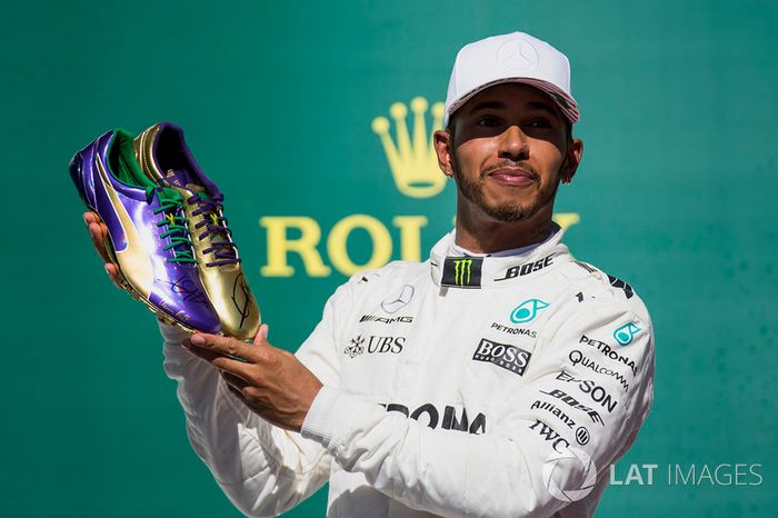 Usain Bolt le regala un par de zapatillas de atletismo al ganador de la carrera de Austin, Lewis Hamilton, Mercedes AMG F1, en el podio