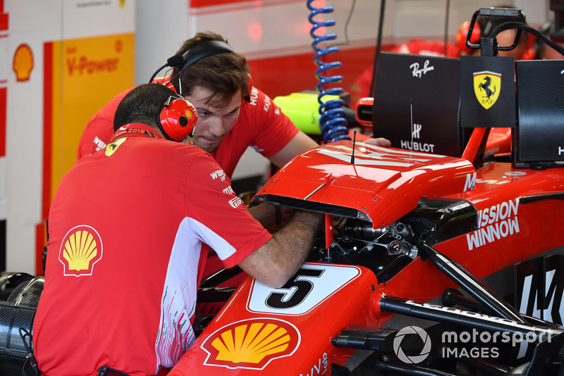 Meccanici Ferrari al lavoro sulla sospensione anteriore della Ferrari SF-71H