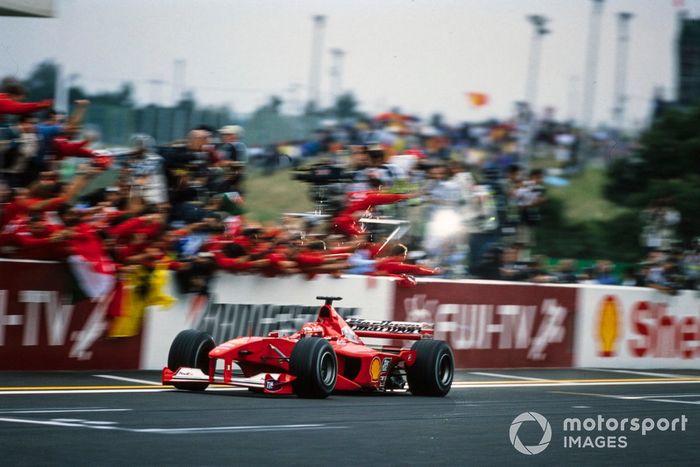 Michael Schumacher, Ferrari F1-2000, cruza la línea de la victoria en la carrera y el campeonato mundial de pilotos