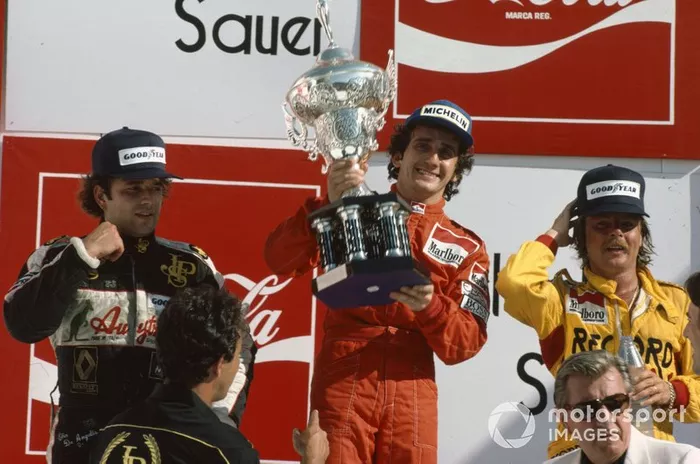 Alain Prost, 1st position,Keke Rosberg, 2nd position, and Elio de Angelis, 3rd position, FISA President Jean-Marie Balestre