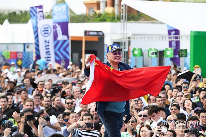 A DS TECHEETAH representative on the podium with a flag of the People's Republic of China