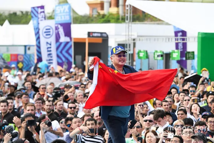 A DS TECHEETAH representative on the podium with a flag of the People's Republic of China