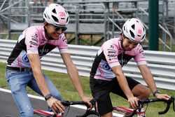 Esteban Ocon, Force India y Sergio Pérez, Force India, andan por el circuito en bicicleta