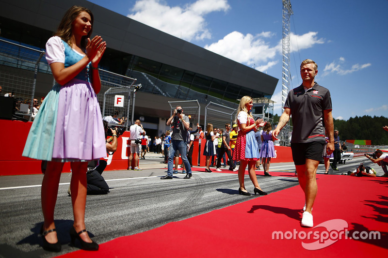 Grid Girls in national costume flank the drivers parade as Kevin Magnussen, Haas F1 Team, passes