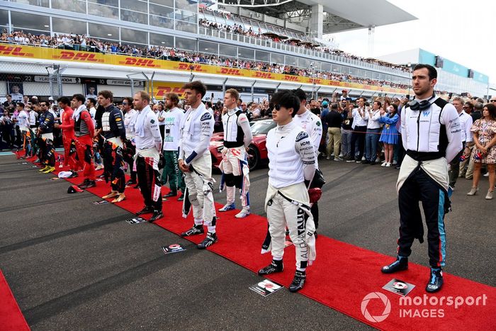 Los pilotos se alinean en la parrilla para el himno nacional antes de la salida