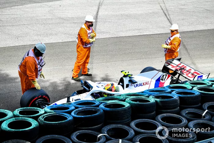 Los oficiales de pista asisten a Mick Schumacher, Haas VF-21, tras su accidente en la FP3