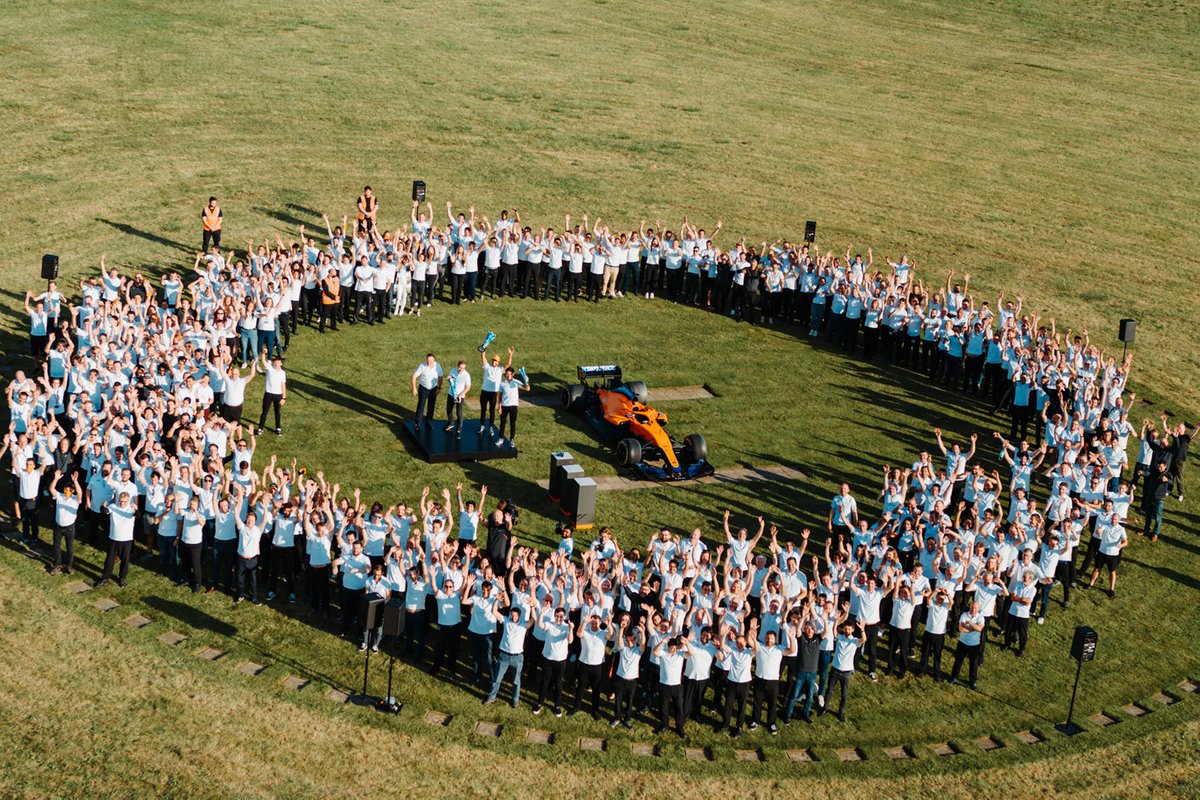 Daniel Ricciardo and Lando Norris celebrate their Monza 1-2 at Woking with McLaren team members