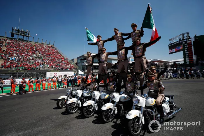 Un equipo de exhibición de motos actúa para el público antes de la salida