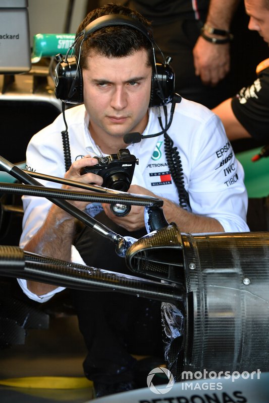 Un meccanico Mercedes a lavoro nel box con una macchina fotografica