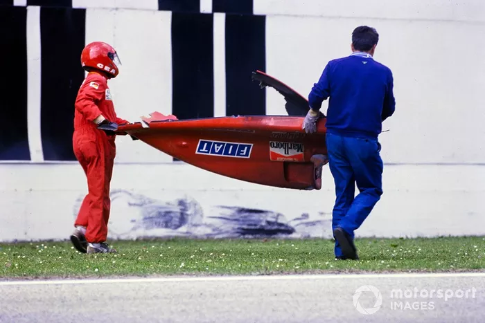 Marshals carry away the rear bodywork of Gerhard Berger's Ferrari 640 after a crash