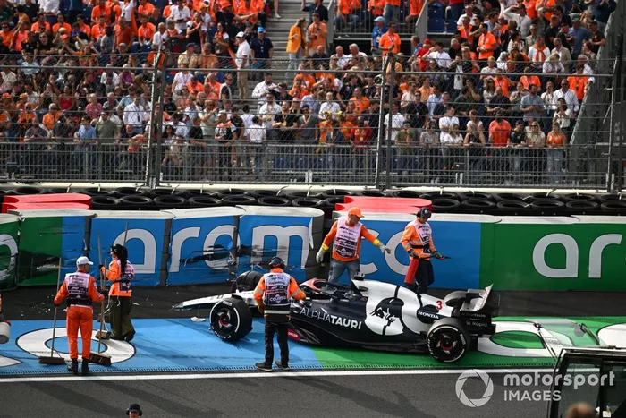 Los comisarios se ocupan del coche dañado de Daniel Ricciardo, AlphaTauri AT04