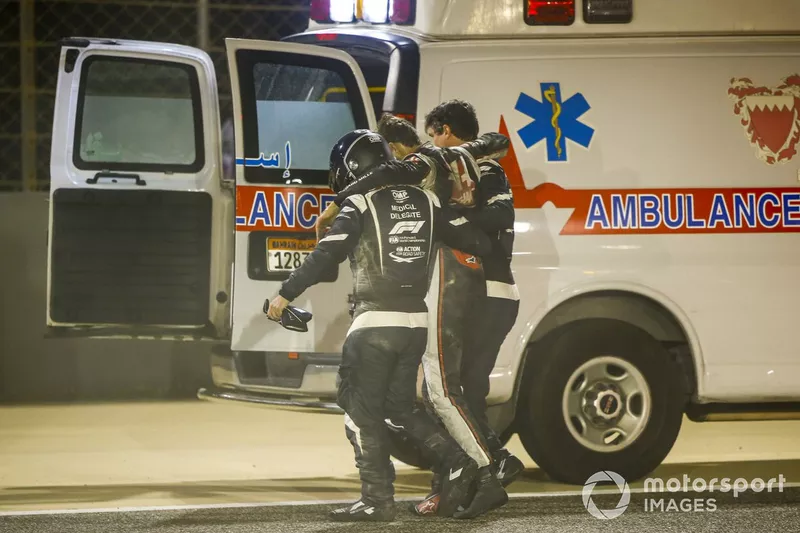 Medical delegates assist Romain Grosjean, Haas F1, after a huge crash on the opening lap