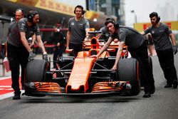 Los miembros del equipo McLaren mueven el coche de Fernando Alonso, McLaren MCL32