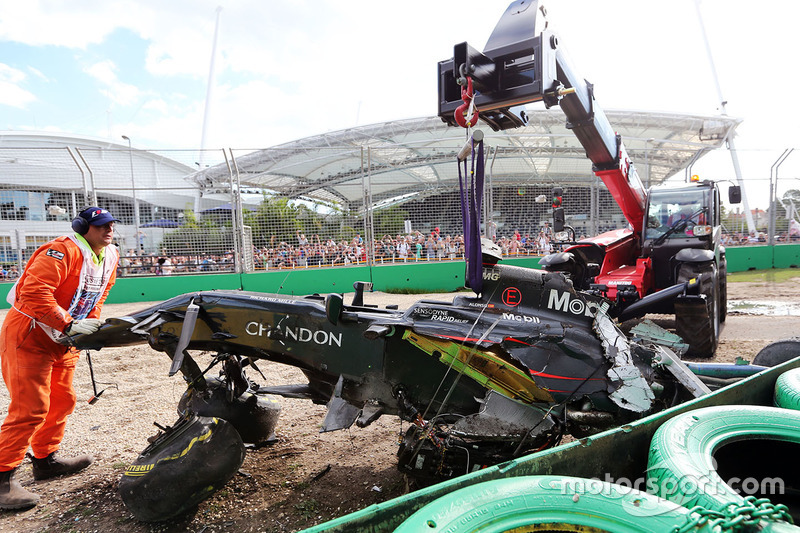 Der McLaren MP4-31 von Fernando Alonso, McLaren, wird aus dem Kiesbett enfernt nach seinem Crash