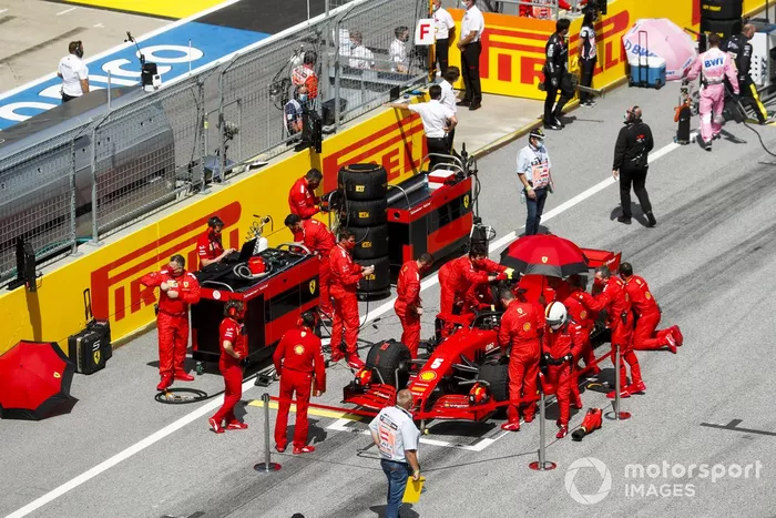 Mecánicos e ingenieros preparan el auto de Sebastian Vettel, Ferrari SF1000, en la parrilla