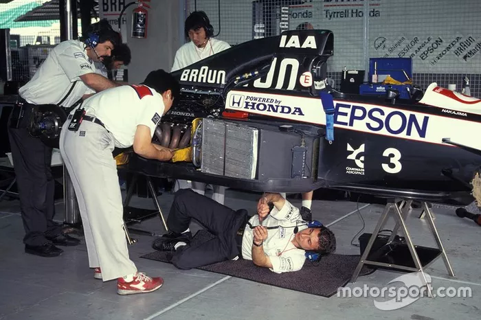 Mechanics work on Satoru Nakajima's Tyrrell 020 Honda in the garage
