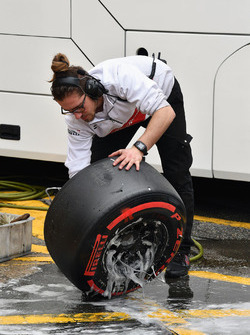 Un mécanicien Alfa Romeo Sauber F1 Team nettoie les pneus Pirelli