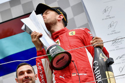 Il vincitore della gara Sebastian Vettel, Ferrari, bacia il trofeo e festeggia sul podio