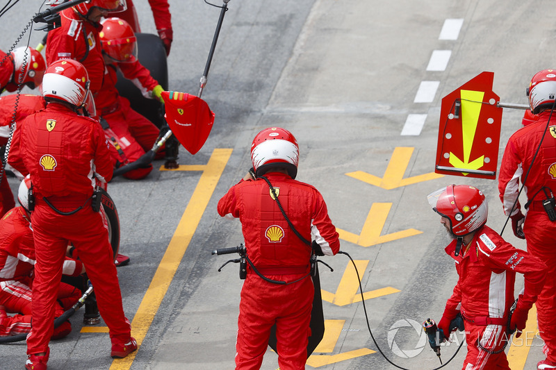 Ferrari mechanics wait for Kimi Raikkonen, Ferrari SF71H, to make a pit stop